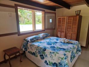 een slaapkamer met een bed en een raam bij Paraíso Verde Arraial d'Ajuda PNM01 in Porto Seguro