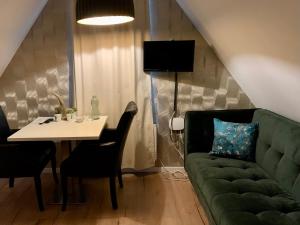 een woonkamer met een groene bank en een tafel bij B&B bij Vincent in Nieuw-Amsterdam