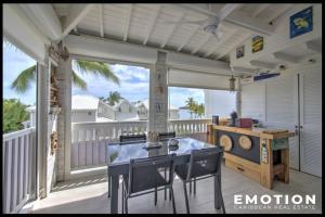 a screened in porch with a table and chairs at Hoani au coeur de la Baie Nettlé in Saint Martin