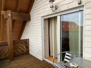 eine Glasschiebetür zu einer Terrasse mit einem Tisch in der Unterkunft ZiniMiri in Freiensteinau