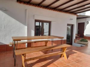 une table et un banc en bois dans une pièce dans l'établissement Villa Carpe Diem en Puerto del Carmen, à Puerto del Carmen