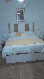 ein Schlafzimmer mit einem großen Bett mit weißer Bettwäsche in der Unterkunft 150m2 Con vistas al Mar y al Castillo de Cullera in Cullera