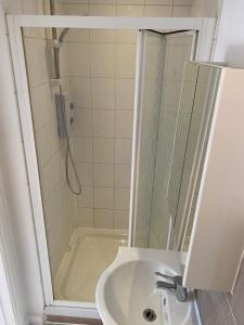 a bathroom with a shower and a sink at Studio on Finchley Road in London