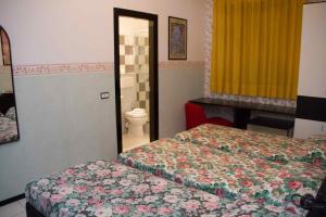 オルテにあるHotel Letiziaのベッド2台とトイレ付きのホテルルームです。