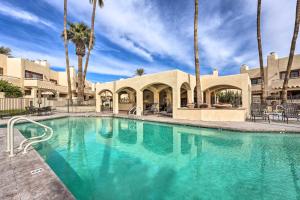 a swimming pool with palm trees in a resort at Scottsdale Condo with Pool Access, Near Old Town! in Scottsdale