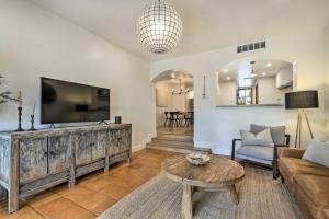 a living room with a tv and a couch and a table at Scottsdale Condo with Pool Access, Near Old Town! in Scottsdale