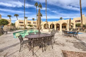 a patio with tables and chairs next to a pool at Scottsdale Condo with Pool Access, Near Old Town! in Scottsdale