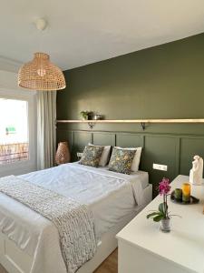 - une chambre avec un lit blanc et un mur vert dans l'établissement Charming appartement in the heart of Barcelona, à Barcelone
