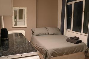 a small bedroom with a bed and a window at Studio on Finchley Road in London