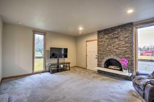 un salon avec une cheminée et une télévision dans l'établissement Luxurious Tacoma Retreat with Quartz Countertops!, à Edgewood
