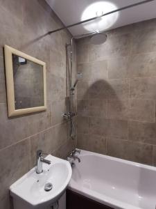 a bathroom with a sink and a tub and a mirror at Lovely 1 Bed Flat in Trendy Peckham in London