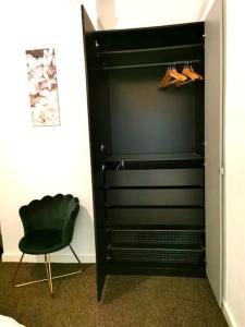 a black closet with a chair and a black cabinet at Lovely 1 Bed Flat in Trendy Peckham in London