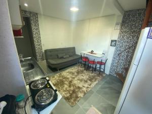 uma cozinha e uma sala de estar com um sofá e uma mesa em Moradas Desterro, próximo ao aeroporto 06 em Florianópolis