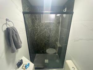 uma casa de banho com uma cabina de duche em vidro e um WC. em Moradas Desterro, próximo ao aeroporto 06 em Florianópolis