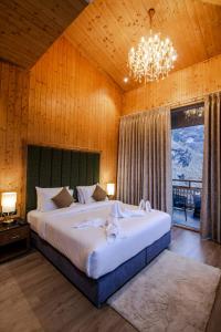 a bedroom with a large bed with a chandelier at Palchan Hotel & Spa - A member of Radisson Individuals Retreats in Manāli
