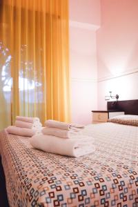 um quarto de hotel com uma cama com toalhas em Hotel Letizia em Orte