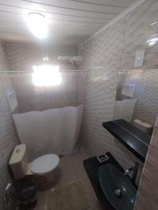 a bathroom with a toilet and a sink at Apart da Cachoeira in Florianópolis