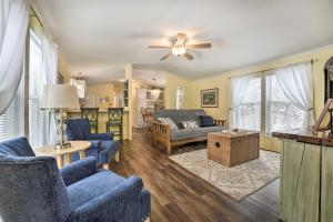 a living room with blue chairs and a ceiling fan at Charming South Haven Home - Great Location! in South Haven
