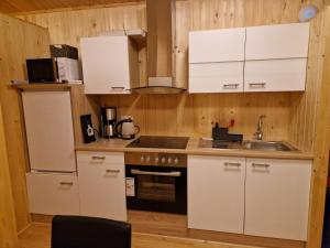 una cocina con armarios blancos y fregadero en Mófellsstaðakot en Borgarnes