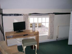 a room with a desk with a computer and a window at The Potters Arms in Amersham