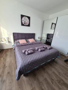 um quarto com uma cama grande com almofadas em Grey & Sunny Apartments Zaječar em Zaječar