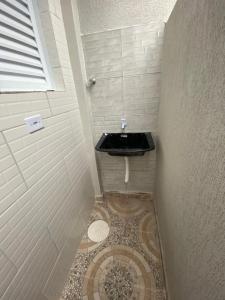 a small bathroom with a sink and a toilet at Casa Guarujá próx. Balsa Santos in Guarujá
