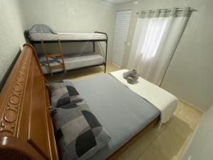 ein Schlafzimmer mit einem Bett und Etagenbetten. in der Unterkunft Casa Guarujá próx. Balsa Santos in Guarujá