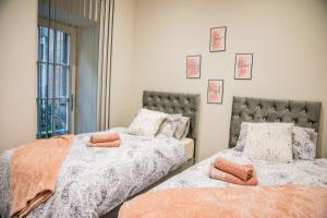 リーズにあるBV Lux 1 Bedroom At Leeds CLiff Oak Mansion Houseのベッドルーム1室(オレンジ色の枕が付いたベッド2台付)