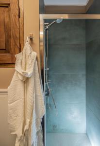 uma casa de banho com um chuveiro e um roupão na parede em una stanza in carmine em Brescia