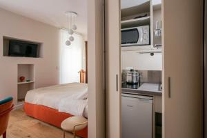 a small room with a bed and a kitchen at una stanza in carmine in Brescia