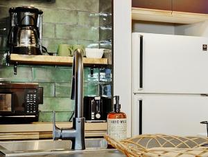 una cocina con fregadero y refrigerador en 24#23 Chemin du Hameau - Studio, en Stoneham