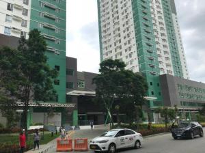 twee hoge gebouwen met auto's geparkeerd op een parkeerplaats bij Avida Towers Riala T3 - Studio Unit 2nd Floor - 224 in Cebu City