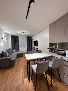 利維夫的住宿－Квартира з Джакузі вулиця Під Голоском 15 стилізована з новим сучасний ремонтом，厨房以及带桌椅的起居室。