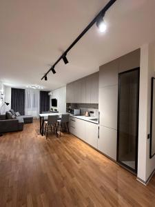 リヴィウにあるКвартира з Джакузі вулиця Під Голоском 15 стилізована з новим сучасний ремонтомの広いリビングルーム(テーブル付)、キッチンが備わります。