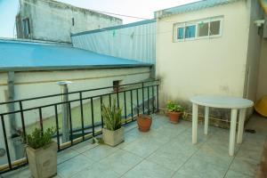 patio con mesa y macetas en el balcón en Apart La Cantora en Gualeguaychú