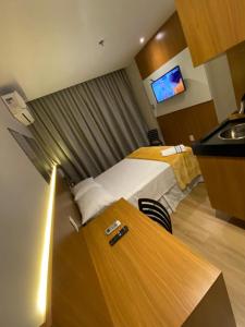 um quarto de hotel com uma cama e uma secretária com um lavatório em Apart-hotel América B em Campos dos Goytacazes