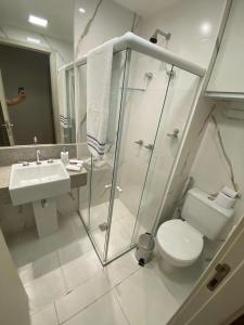 a bathroom with a shower and a toilet and a sink at Apart-hotel América B in Campos dos Goytacazes