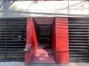 una porta rossa sul lato di un edificio di Private bedroom in Roma Norte in Mexico City a Città del Messico
