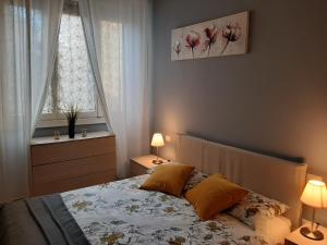 a bedroom with a bed with two lamps and two windows at Appartamento vicino aeroporto in Florence