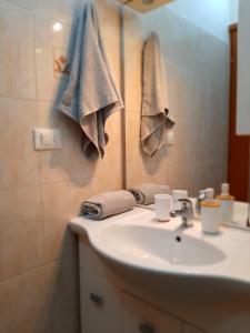 bagno con lavandino, specchio e asciugamani di Appartamento vicino aeroporto a Firenze