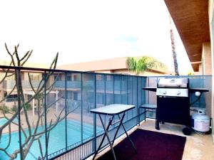 a balcony with a grill and a swimming pool at Sunrise Springs 1-Bedroom with Balcony & Pool in Palm Springs +13 photos
