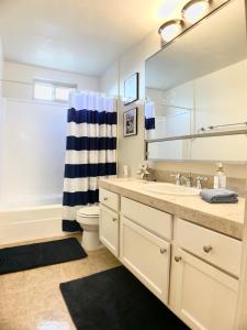 a bathroom with a sink and a toilet and a mirror at Sunrise Springs 1-Bedroom with Balcony & Pool in Palm Springs