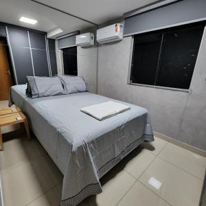 um pequeno quarto com uma cama e uma janela em LOFT ACONCHEGANTE COM ALEXA em Belo Horizonte