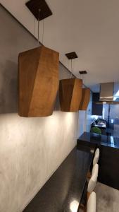 una cocina con dos luces colgando del techo en LOFT ACONCHEGANTE COM ALEXA en Belo Horizonte