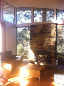 a living room with a stone fireplace at Southern Ocean Retreats - Deep Creek National Park in Delamere