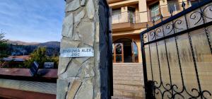 a sign on a gate in front of a house at Pensiunea Alex in Cheia