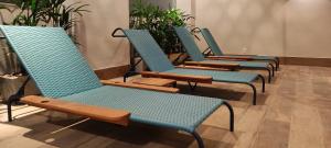 a row of blue chairs in a room with plants at Kastel Petrópolis in Petrópolis