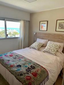 Un dormitorio con una cama con una manta floral. en Divino departamento a estrenar en la península., en Punta del Este