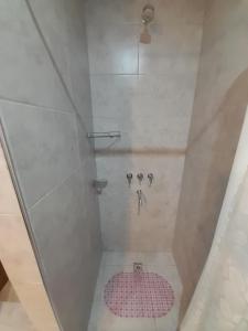 y baño con ducha y alfombra rosa. en Departamento tipo duplex en San bernardo n°3 en San Bernardo