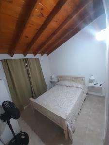 1 dormitorio con cama y techo de madera en Departamento tipo duplex en San bernardo n°3 en San Bernardo